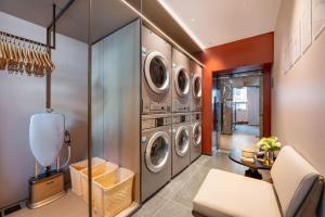 a laundry room with three washer and dryer at Atour Hotel Changsha Pedestrian Street IFC Center in Changsha