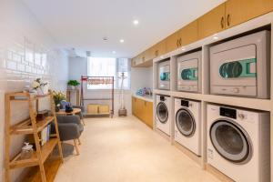 a laundry room with two washer and dryer machines at Atour Hotel Xiamen Lianban Mingfa Plaza in Xiamen