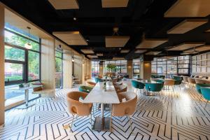 a restaurant with tables and chairs and windows at Atour Hotel Hongqiao Hub National Exhibition Center Shanghai in Shanghai
