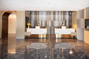 a lobby of a hotel with two people sitting at desks at Atour Hotel South Jinan Industrial Road CBD in Jinan +16 photos