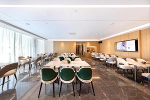 una sala de conferencias con mesas, sillas y una pantalla en Atour Hotel Shenzhen Qianhai Baoan Center, en Bao'an