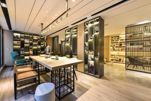 a wine tasting room with a table and chairs and shelves at Atour Hotel Dalian Development Zone Jinma Road in Dalian