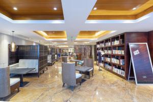 a library with tables and chairs and bookshelves at Atour X Hotel Shenzhen Luohu Dongmen Pedestrian Street in Shenzhen