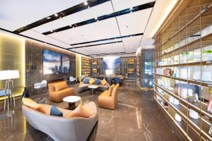 a library with couches and chairs and books at Atour Hotel Shenzhen Shajing International Convention and Exhibition Center in Bao'an