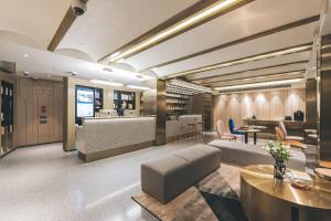 a lobby with a couch and tables and a bar at Atour Light Hotel Shanghai East Nanjing Road 130 in Shanghai