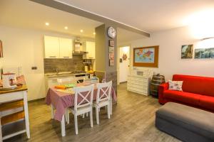 a kitchen and living room with a table and a red couch at Tizi House in Varenna