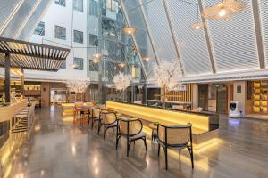 a restaurant with chairs and tables in a building at Atour Hotel Guangzhou Zhujiang New Town Wuyangtun in Guangzhou