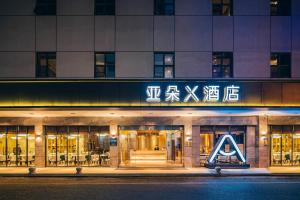 un negozio di fronte a un edificio di notte di Atour X Hotel Xiamen Zhongshan Road Ferry Wharf a Xiamen