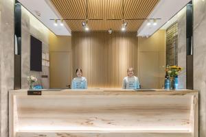 two women sitting at a counter in front of a mirror at Atour X Hotel Xiamen Zhongshan Road Ferry Wharf in Xiamen