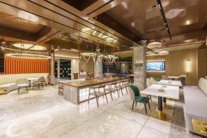 um restaurante com mesas e cadeiras e um bar em Atour Hotel Dalian Airport em Dalian