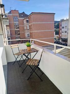 d'un balcon avec deux chaises et une table sur le toit. dans l'établissement Colindres centro La casita de Nani, ideal niños y teletrabajo, à Colindres