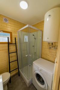 a bathroom with a shower and a washing machine at Chalet d'Aroeira in Corroios