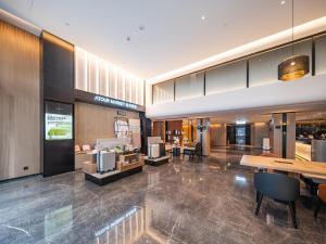a lobby with tables and chairs in a building at Atour Hotel Chengdu Taikoo Li Chunxi Road Pedestrian in Chengdu