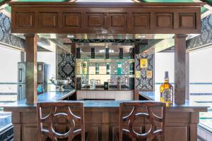 a kitchen with a bar with two chairs at it at Villa Mountain Crest Kasauli with Treehouse & Sundeck in Dagshai