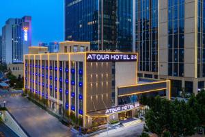 un edificio de hotel con un cartel en una ciudad en Atour Hotel South Jinan Industrial Road CBD en Jinan