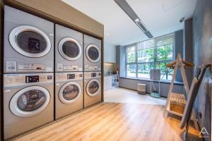 a laundry room with four washing machines and a window at Atour Hotel South Jinan Industrial Road CBD in Jinan