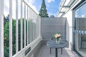 a table on a balcony with a vase of flowers at Atour Light Hotel Shanghai East Nanjing Road in Shanghai