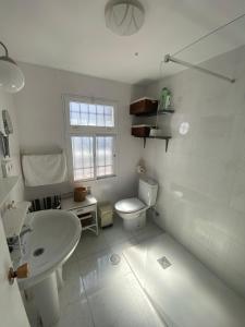 La salle de bains blanche est pourvue de toilettes et d'un lavabo. dans l'établissement Casa Andrés, à Arriate