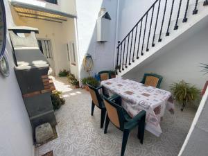 a patio with a table and chairs and a staircase at Casa Andrés in Arriate