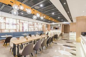 a restaurant with tables and chairs in a cafeteria at Atour Hotel Shanghai Hongqiao Korea Street in Shanghai
