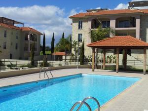 a swimming pool in front of a building at Mazotos Panoramic Village in Mazotos