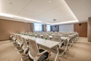 uma sala de conferências com mesas brancas e cadeiras brancas em Atour Hotel Zhuhai Jinwan Airport em Zhuhai