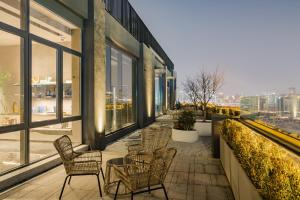 a balcony with chairs and tables on a building at Atour S Hotel Shanghai Lujiazui Expo Center in Shanghai