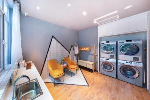 a laundry room with two washing machines and a table and chairs at Atour Hotel Chengdu High-tech Tianfu 2nd Street in Chengdu