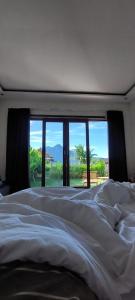 a bedroom with a large white bed with a view at Mahadanu Villa & Glamping in Kintamani