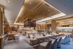 a restaurant with tables and chairs and a kitchen at Atour X Hotel Shenzhen Futian CBD Chegongmiao in Shenzhen