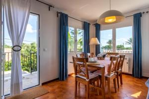 a dining room with a table and chairs and windows at Can Joan in Santanyi