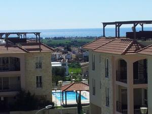 a view of two apartment buildings and a swimming pool at Mazotos Panoramic Village in Mazotos