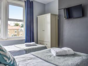sypialnia z dwoma łóżkami i telewizorem na ścianie w obiekcie South Villa w mieście Sandsend