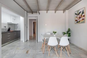 cocina y comedor con mesa y sillas en Apartamentos Realejo Granada Centro 3000, en Granada