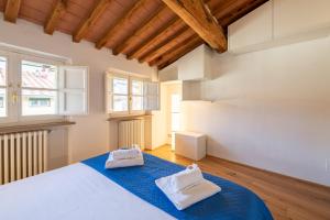een slaapkamer met een bed met twee handdoeken erop bij CASA SAN PAOLINO [Dentro le mura]Elegant Flat WIFI e SelfCheckin in Lucca