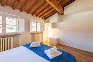 a bedroom with a bed with two towels on it at CASA SAN PAOLINO [Dentro le mura]Elegant Flat WIFI e SelfCheckin in Lucca