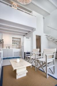 a living room with white chairs and a table at Hidden Gem Authentic cycladic house in Paros in Márpissa