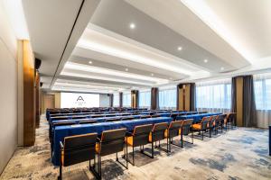 廈門市にあるAtour Hotel Xiamen Zhongshan Road General Templeの青い椅子とスクリーンが備わる講堂