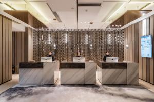 two people sitting at a reception desk with laptops at Atour Hotel Guanyin Bridge Chongqing in Chongqing