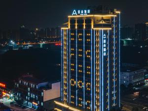 oświetlony budynek w mieście w nocy w obiekcie Atour Hotel Chongqiang Jiangbei Airport w mieście Chongqing