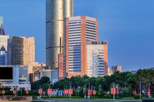 a tall building with a sign on it in a city at Atour X Hotel Jinan Quancheng Plaza in Jinan