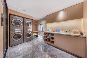 a laundry room with three washing machines and a sink at Atour X Hotel Jinan Quancheng Plaza in Jinan