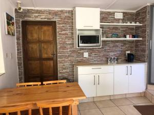 a kitchen with a wooden table and a brick wall at Roberto's in Hilton