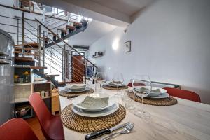 a table with chairs and plates and wine glasses at YID Oltrarno segreto in Florence