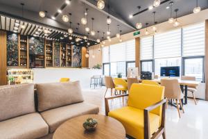 una sala de estar con sofá, mesas y sillas en Atour Hotel Shanghai Lujiazui Minsheng Road Station, en Shanghái