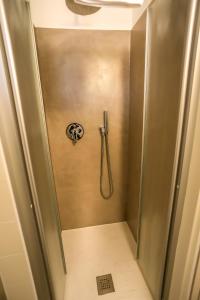 a shower stall in a bathroom with a hose at Tizi House in Varenna