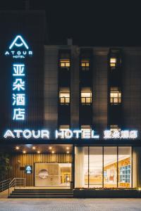 un hôtel avec un panneau à l'avant de celui-ci la nuit dans l'établissement Atour Hotel Shanghai New International Expo Center Maglev Station, à Shanghai