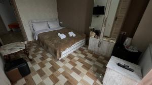 a bedroom with a bed with two towels on it at Hotel Tourist in Tbilisi City