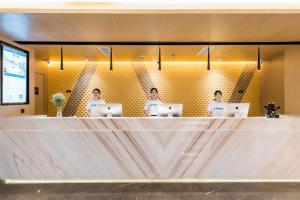 drie mannen aan een toonbank met hun laptops bij Atour Hotel Suzhou Guanqian Street in Suzhou