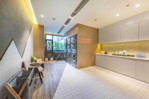 a large kitchen with a counter and chairs and tables at Atour S Hotel Jinan Baotu Spring in Jinan